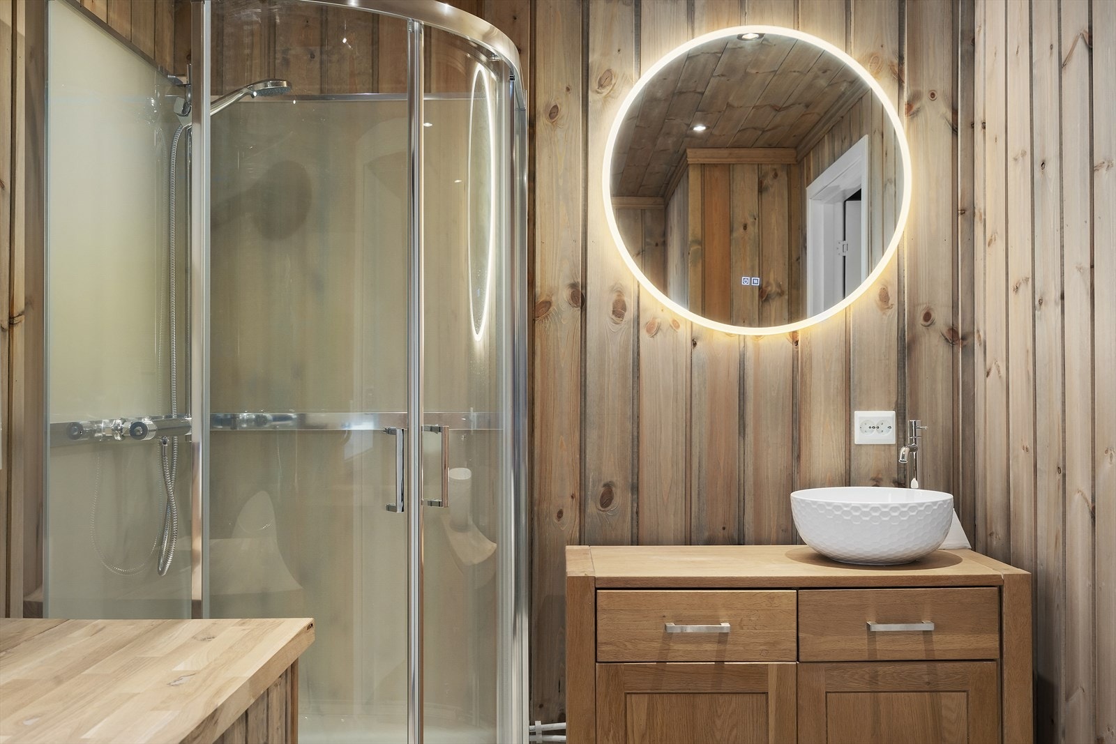 Trivelige overflater med trepanel på vegger og himling kombinert med praktisk vinylbelegg på gulv. Galleribilde