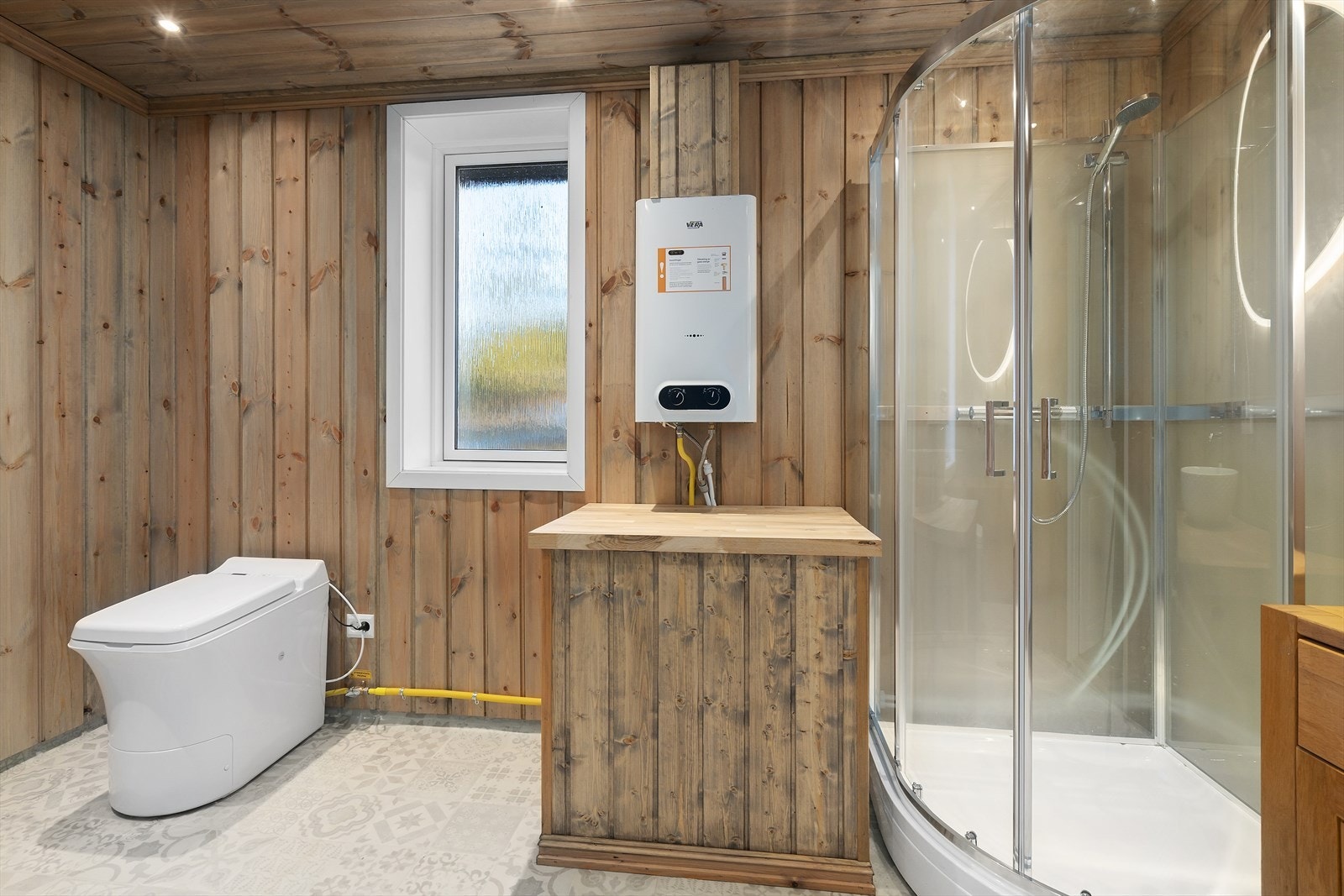 Lyst og funksjonelt toalettrom med dusjkabinett, servantskap og forbrenningstoalett fra Cinderella. Galleribilde