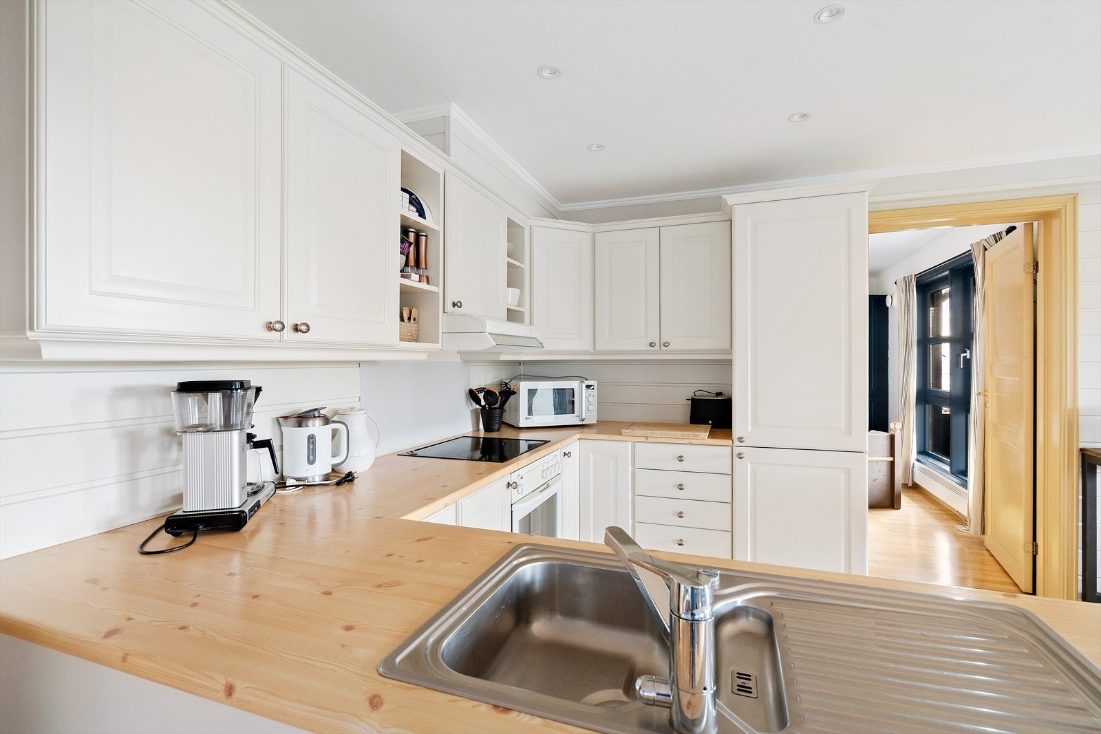 Lyst og funksjonelt kjøkken med profilerte fronter og laminatbenkeplate. Galleribilde