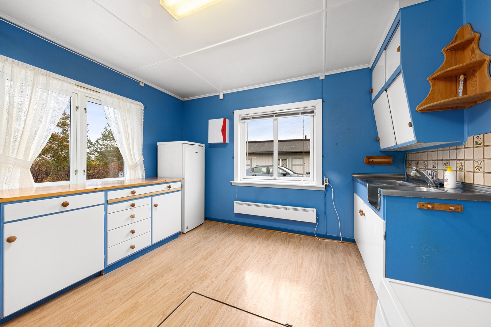 Kjøkkenet har en eldre innredning med glatte fronter og benkeplate i heltre. Galleribilde