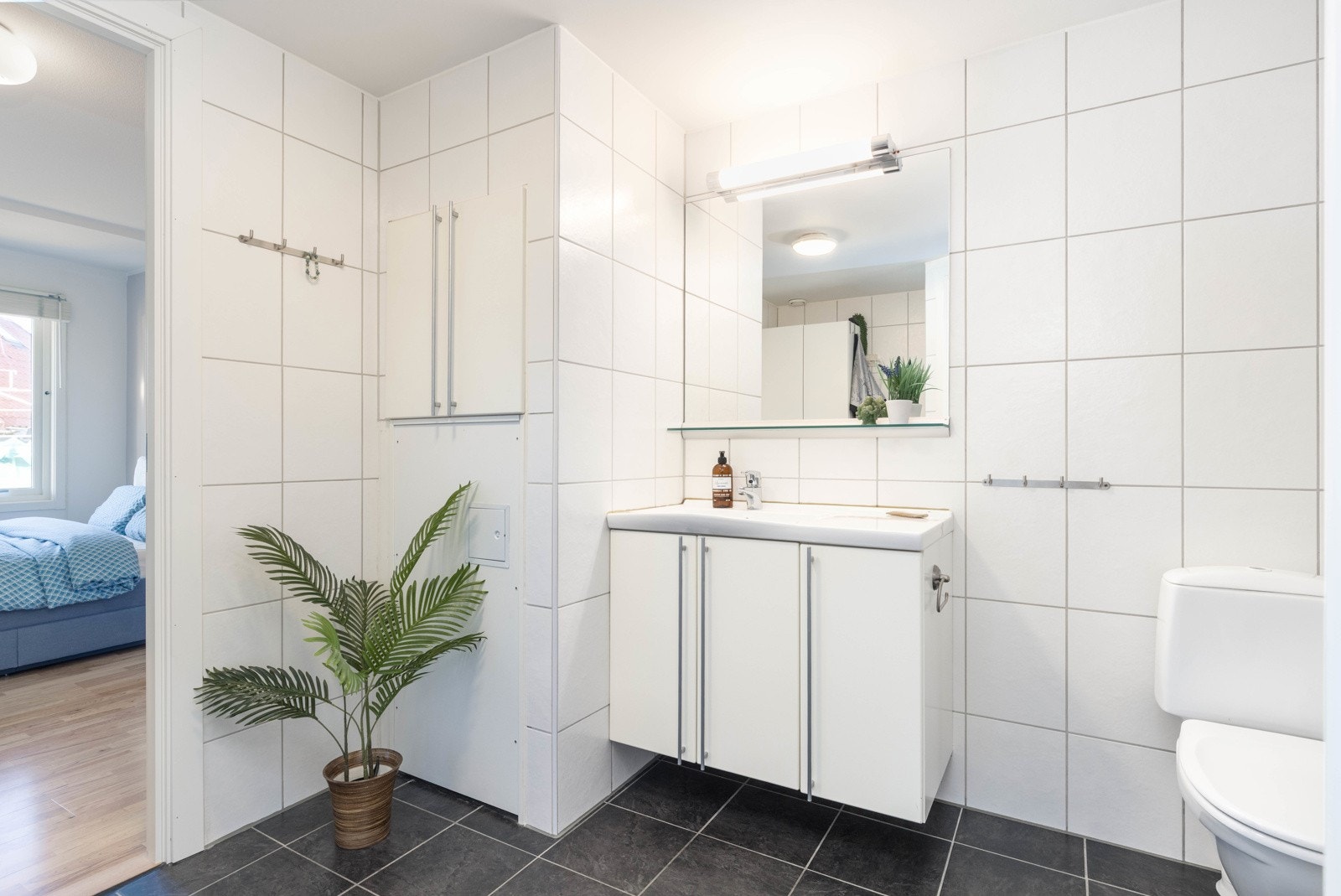 Det helflisede badet har tilkomst fra både soverom og entrè. Galleribilde