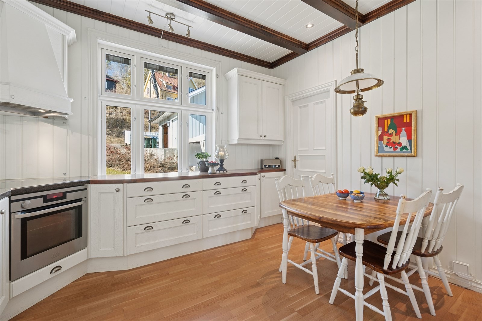 Det er montert lys, klassisk og stor kjøkkeninnredning med profilerte fronter fra Huseby. Kjøkkeninnredningen strekker seg rundt i rommet og gir utmerket oppbevaringsplass og benkearealer. Galleribilde