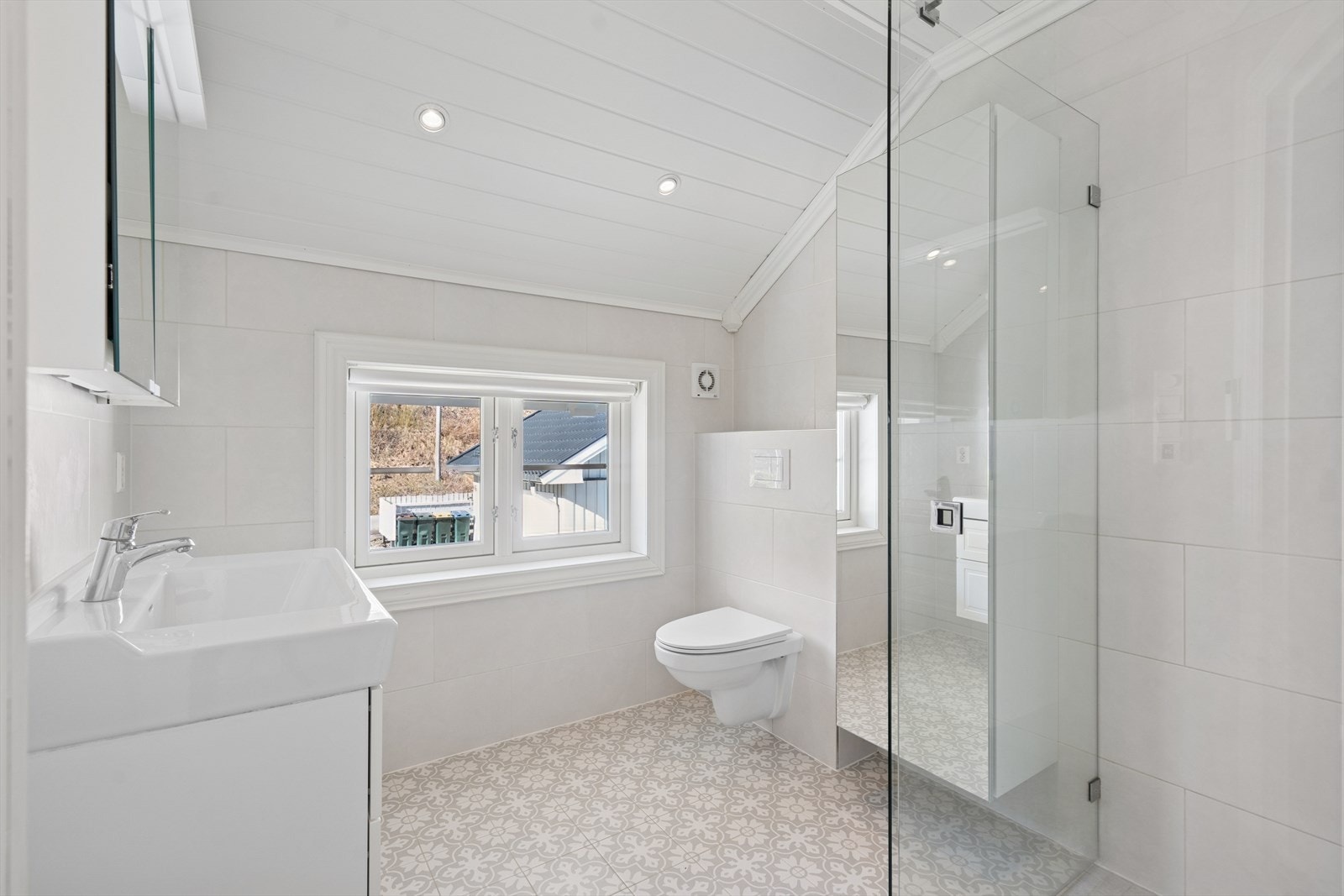 Boligen har et nydelig og fullverdig baderom som ble renovert i 2018 i regi av fagfolk. Gulvet er belagt med fine og mønstrede fliser, mens veggene er belagt med lyse og tidløse fliser som føyer seg pent inn i gulvflisene. Galleribilde