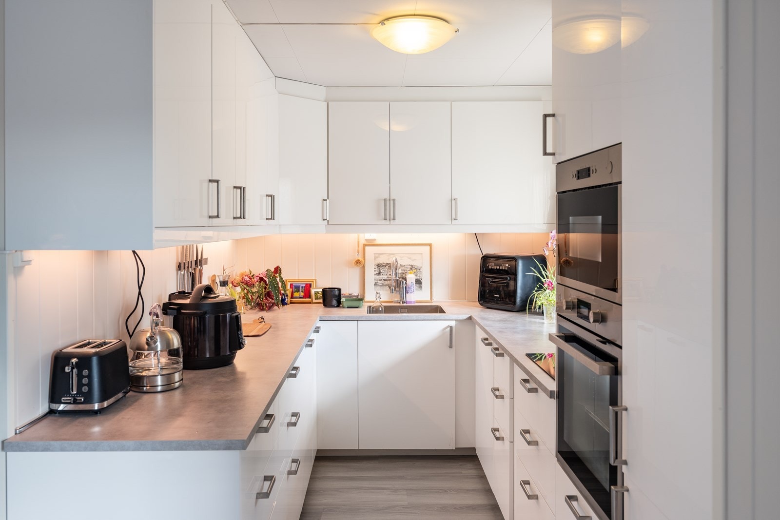 Moderne kjøkken i U-løsning med god benke- og skapplass. Galleribilde