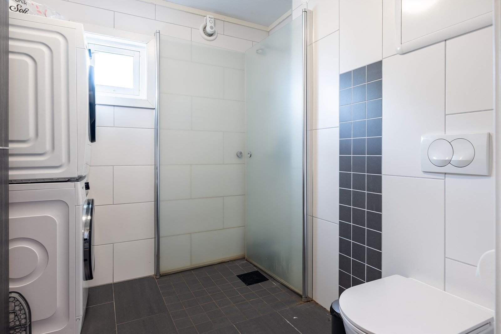 Utstyrt med innfellbare dusjdører, vegghengt toalett, servantskap samt opplegg for vaskemaskin og tørketrommel. Galleribilde