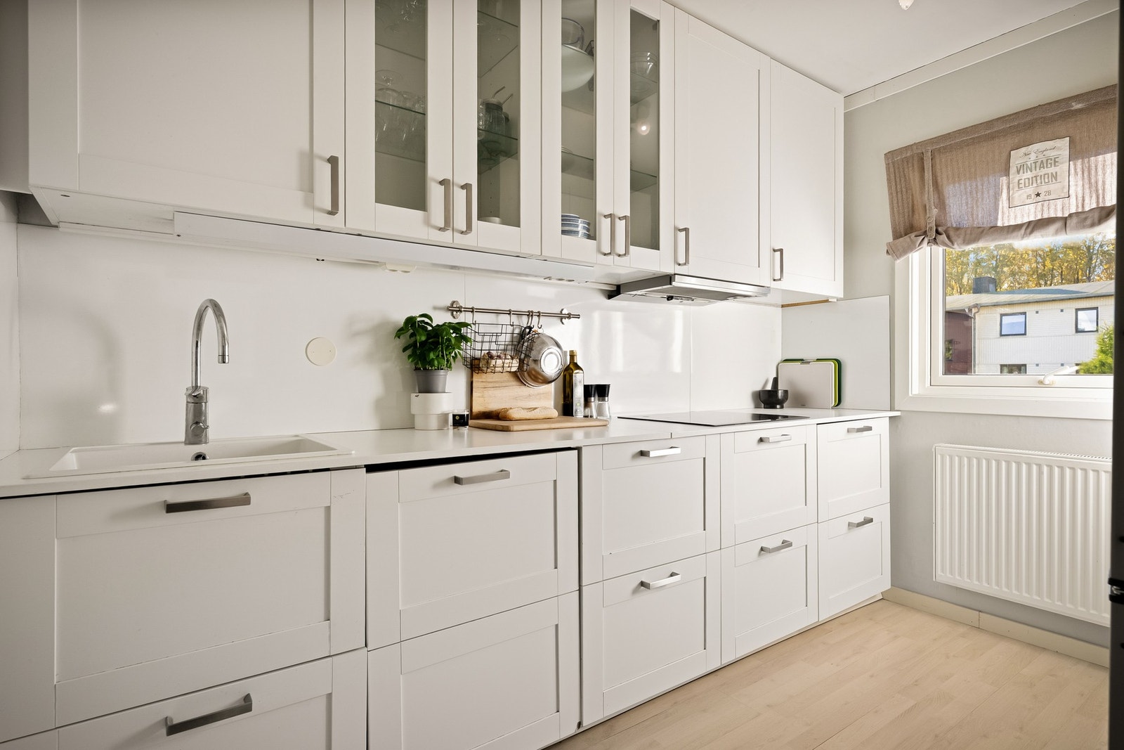 Lyst IKEA-kjøkken fra 2017 med integrerte hvitevarer og god benkeplass Galleribilde