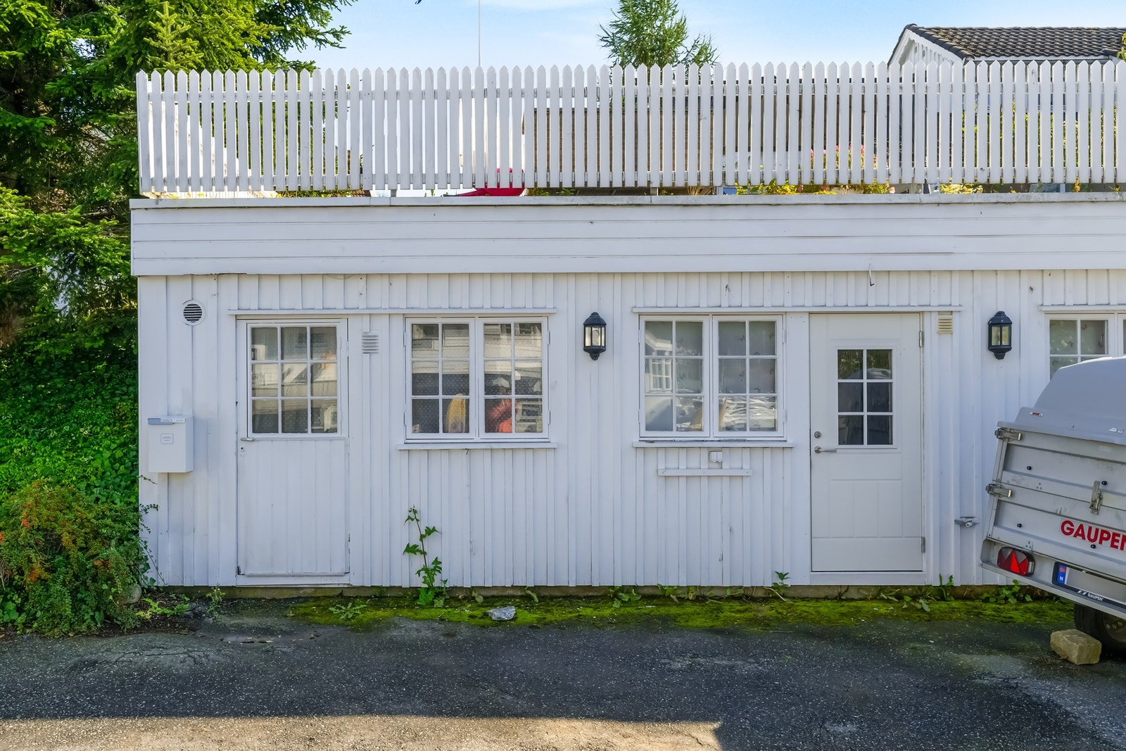 Stor og praktisk bod til lagring under takterrasse. Den tilhørende boden er inn døren til venstre. Parkeringsplass foran bygget. Galleribilde