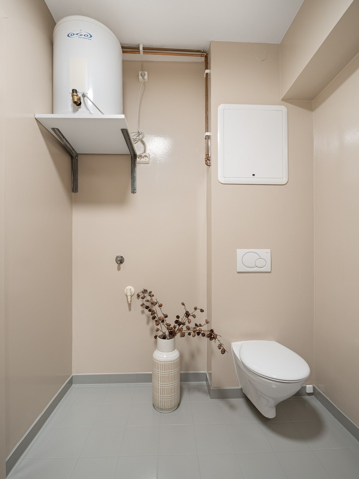 Det inneholder vegghengt toalett, dusjhjørne med innfellbare glassdører, servant med underskap og opplegg for vaskemaskin. Her er også varmtvannsberederen plassert. Galleribilde