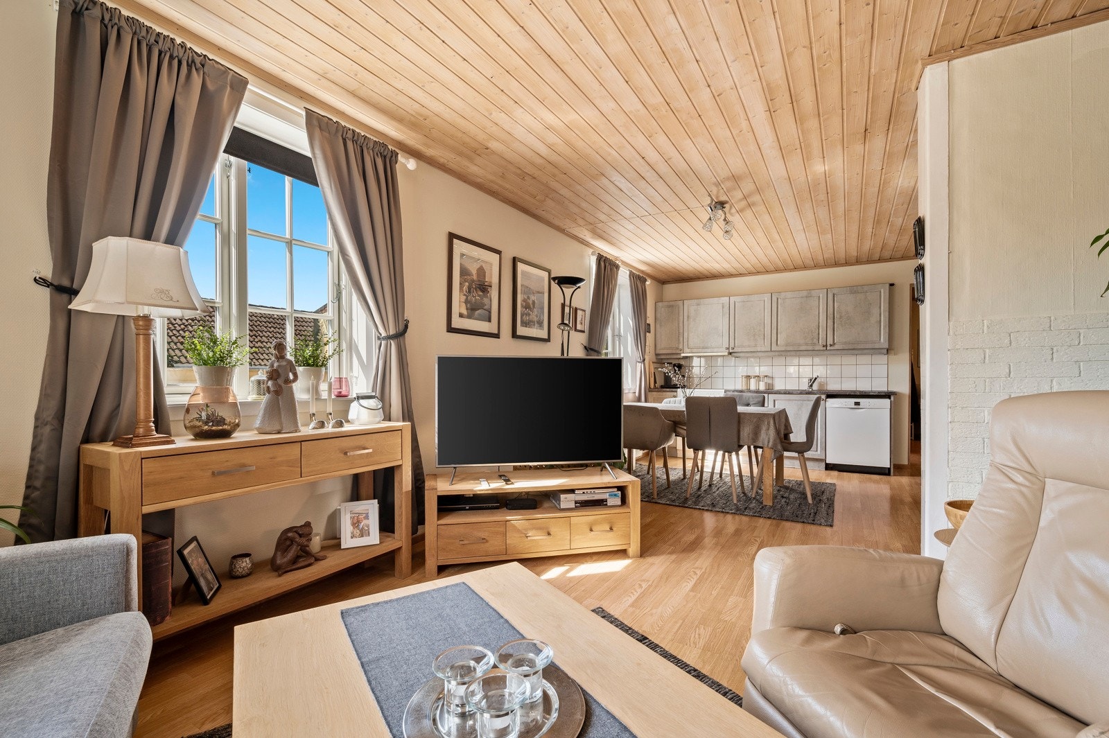 Stuen ligger i en åpen løsning med kjøkken og har gjennomgående lyse og varme fargetoner - så her får du en avslappende og komfortabel sone Galleribilde