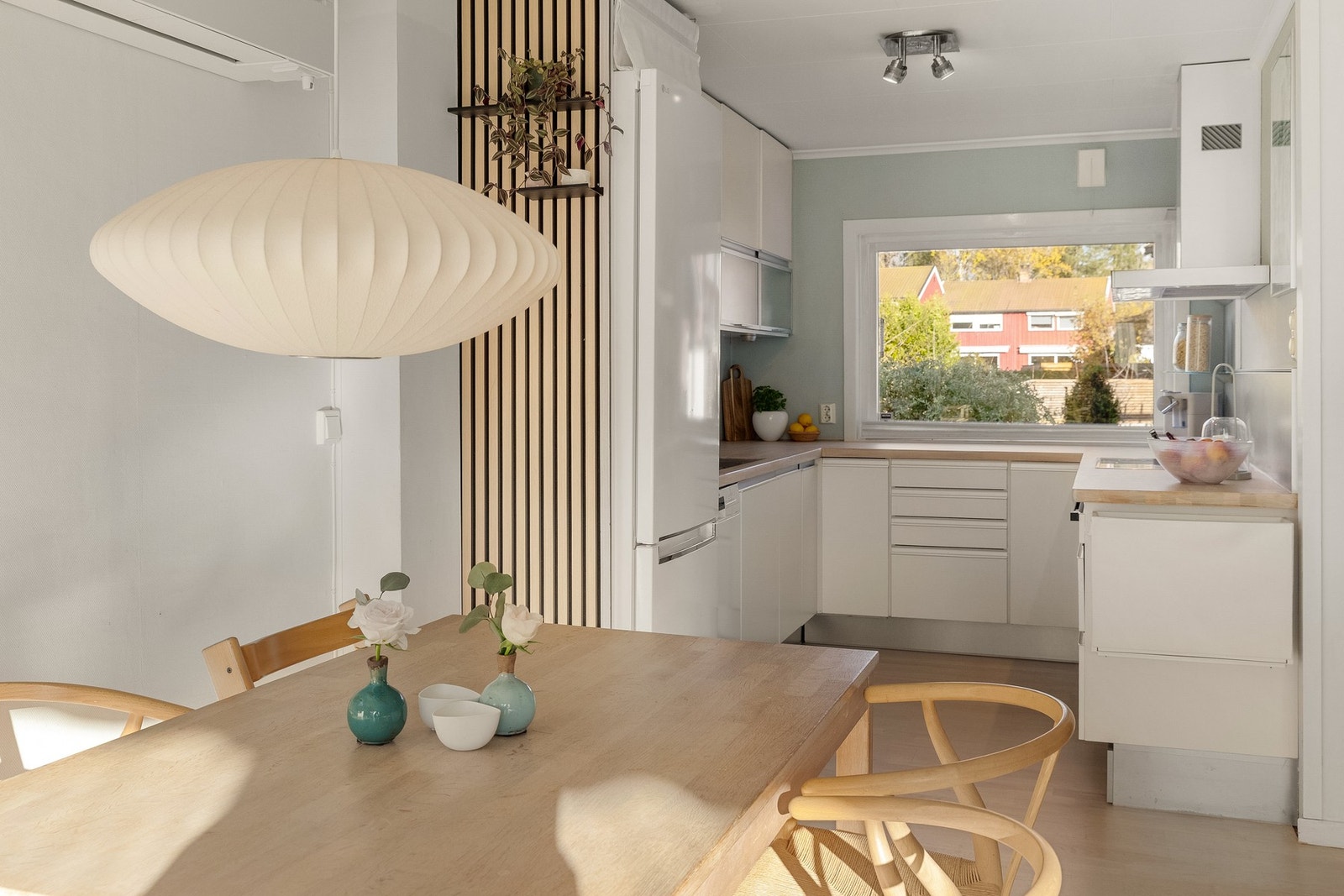 Stilrent HTH-kjøkken fra 2007 med glatte, hvite fronter og benkeplate i heltre med nedfelt stålkum. Galleribilde