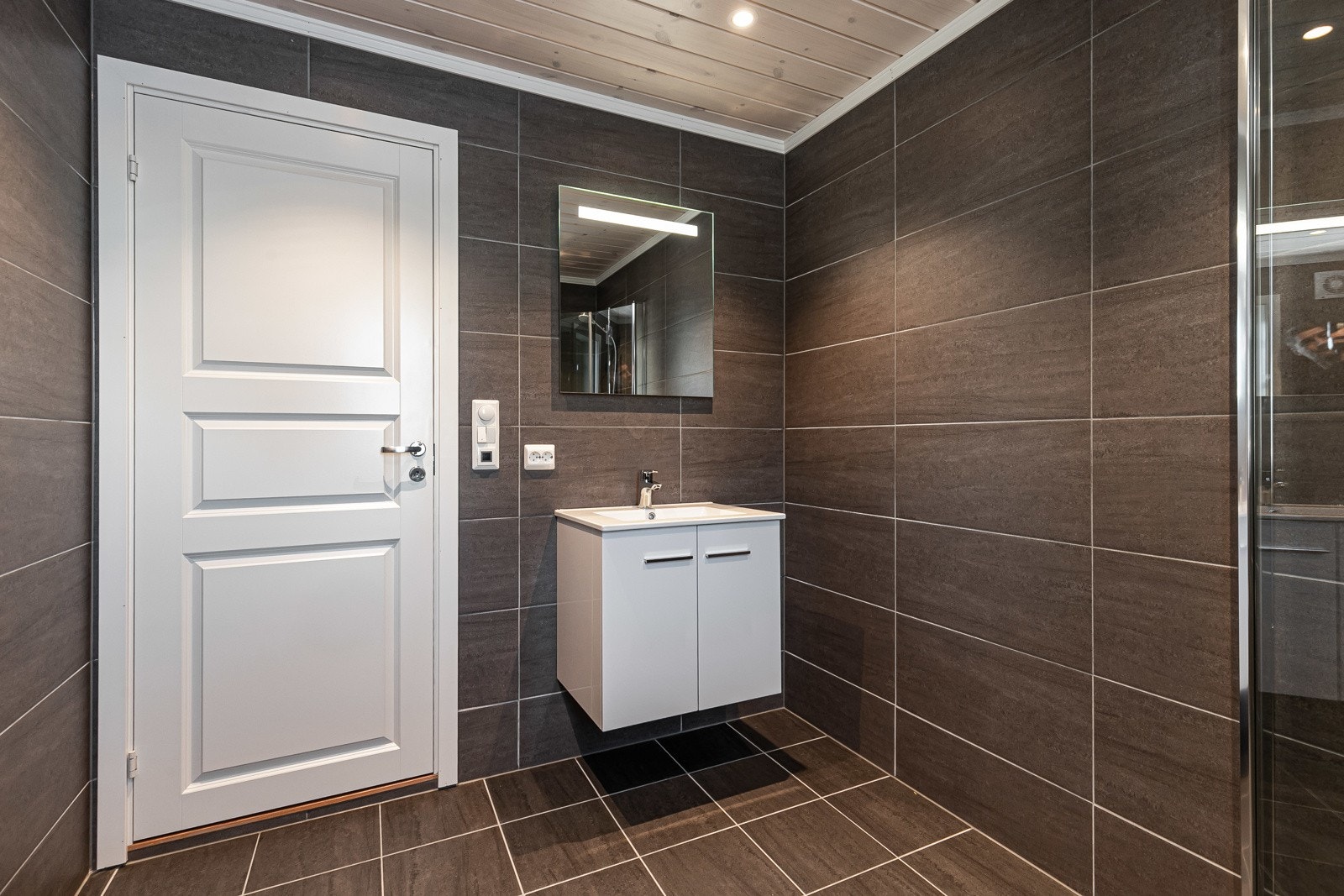 Badet får behagelig gulvvarme, dusjnisje med innfellbare dusjvegger og opplegg til vaskemaskin/tørketrommel. Bildet er kun for å vise leveranse, det er ikke av selve hytta. Galleribilde