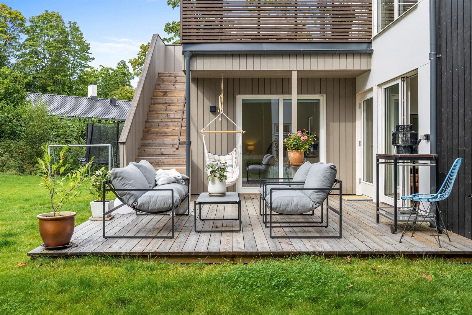 Utgang fra boligen til en markterrasse med videre adkomst til plen. Galleribilde