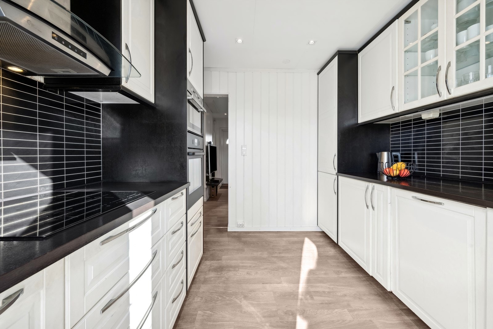 Benkeplaten er laget av laminat, og kitchenboard pryder veggen over benken. Galleribilde