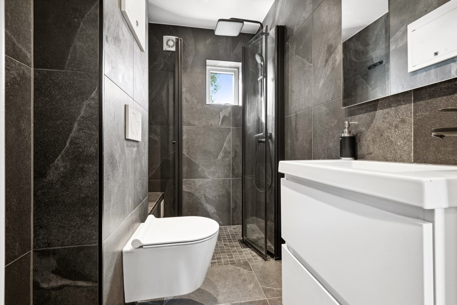 Boligen har to bad og badet i 1.etasje ble pusset opp i 2022 og har flislagte vegger og himling med downlights. Dusjhjørnet er utstyrt med to foldbare glassdører og et to-greps blandebatteri. Galleribilde