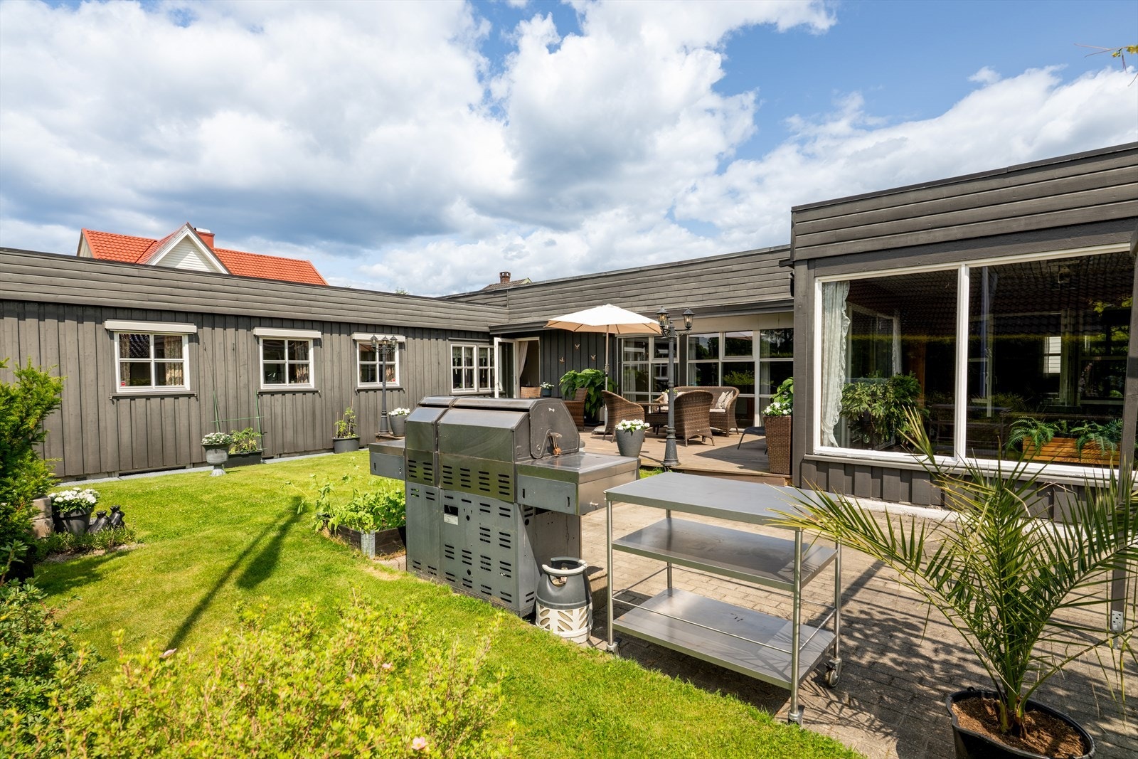 Videre er det en hellelagt uteplass med flott pergola. Galleribilde