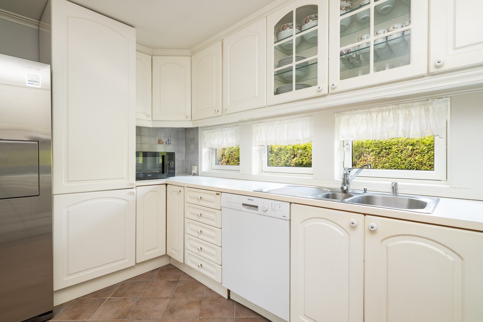 Kjøkken har lys Huseby innredning med profilerte fronter og benkeplate av laminat med flis over. Her er det god skap- og benkeplass. Galleribilde