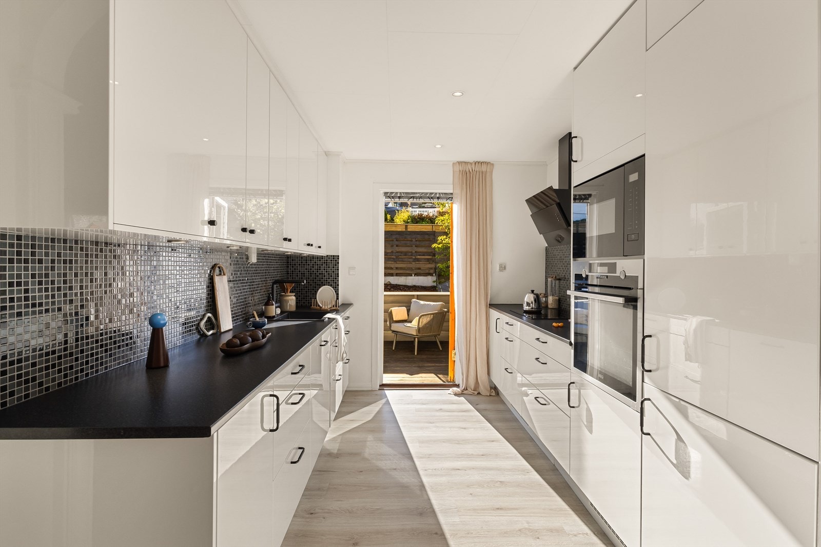 Kjøkkenet er levert av Epoq i 2022 med slette, hvite fronter og alle hvitevarer integrert. Galleribilde