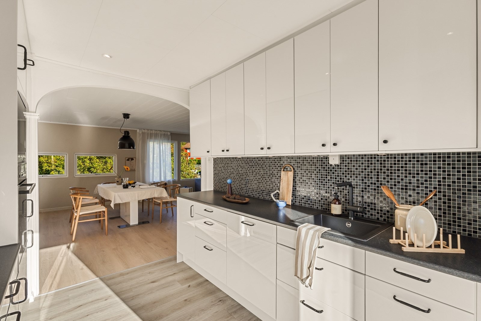 Matlagingen blir sosial med åpen løsning - samtidig delvis skjermet fra sofagruppen i stuen. Galleribilde