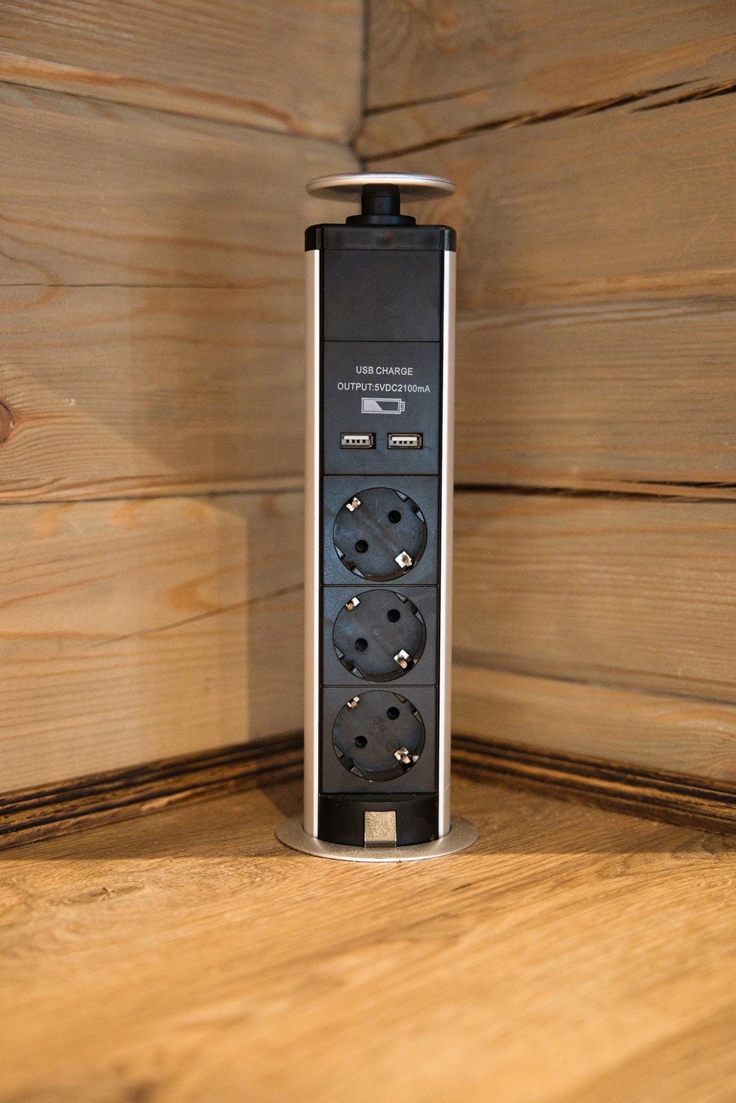 Det er vitrineskap i hjørnene, og nedfelt i en benkeplate av laminat har kjøkkenet pop-up stikk og sort oppvaskkum Galleribilde