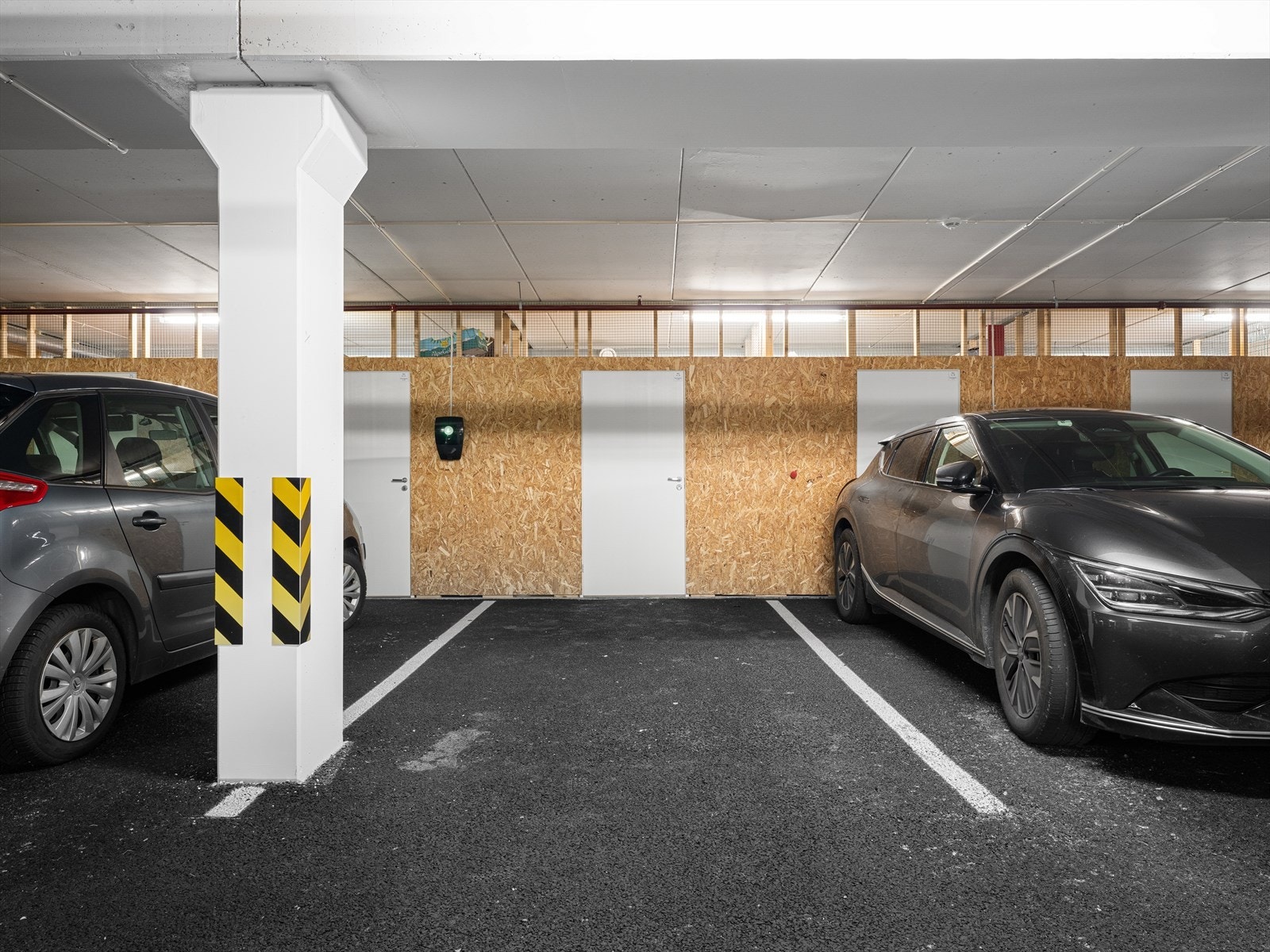 Moderne parkeringsanlegg med mulighet for el-bil lader. Bod plassert i bakkant av parkeringsplass Galleribilde