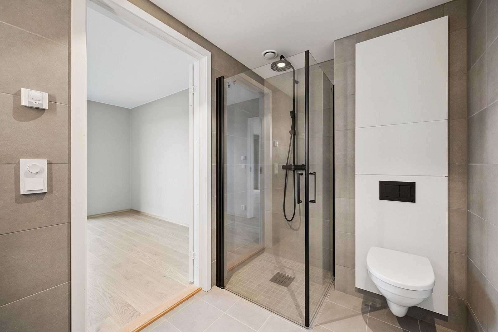 Romslig dusjnisje med glassdører og stilrent armatur. Galleribilde