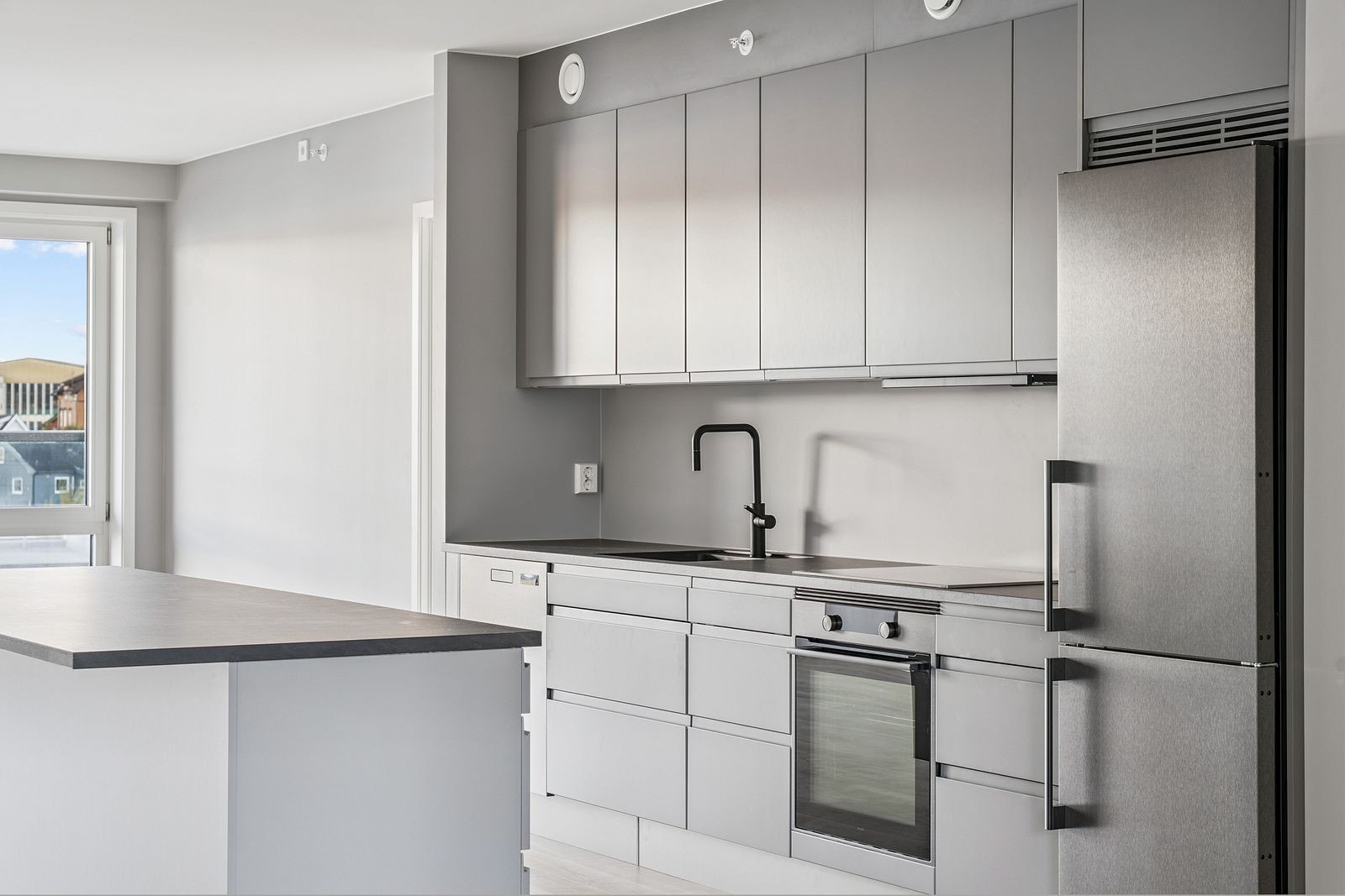 Stilrent kjøkken fra HTH med slette fronter, god arbeidsflate og kjøkkenøy Galleribilde