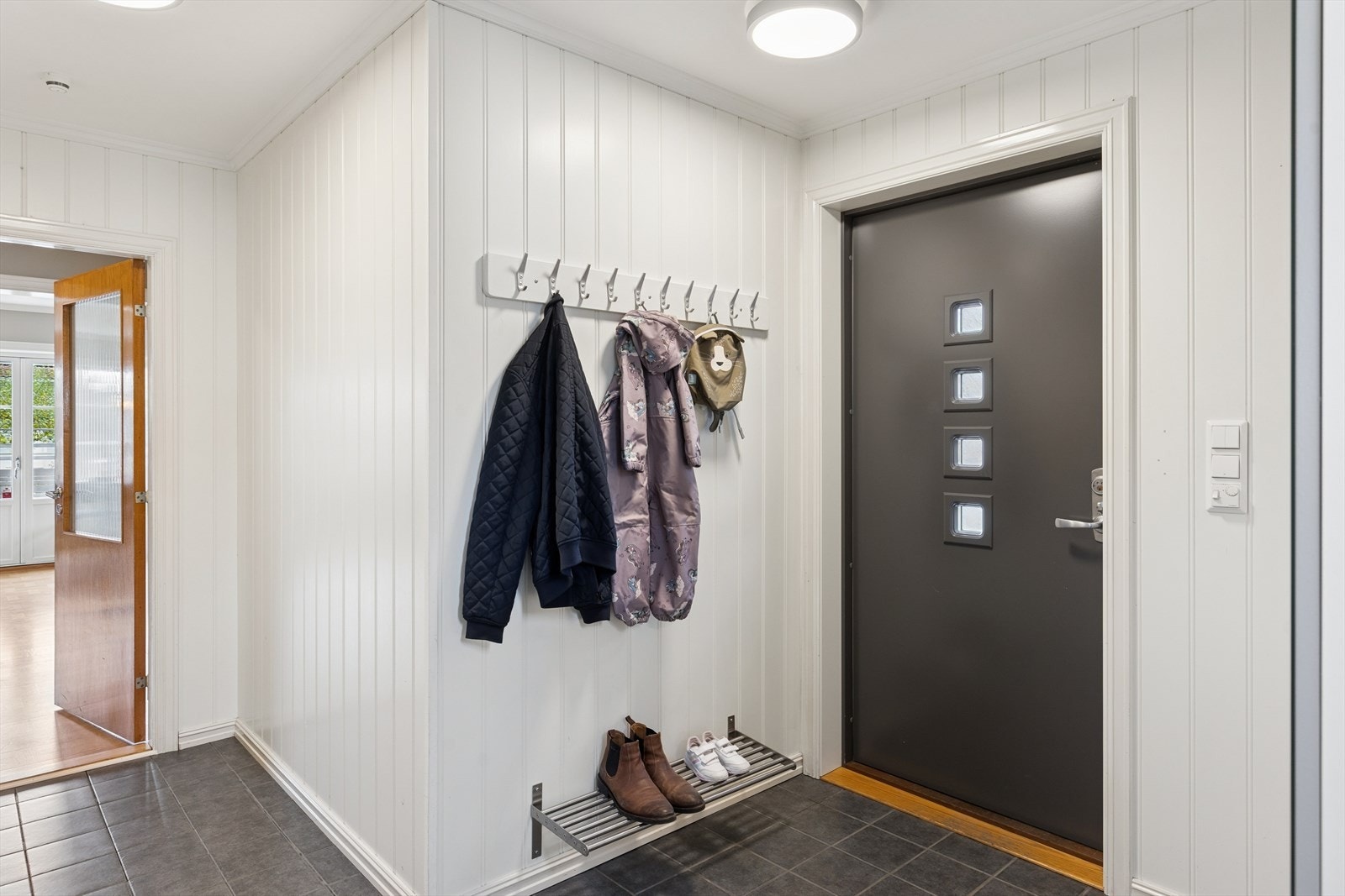 Romslig, flislagt entré hvor man har god plass til å henge fra seg yttertøy og sko. Galleribilde