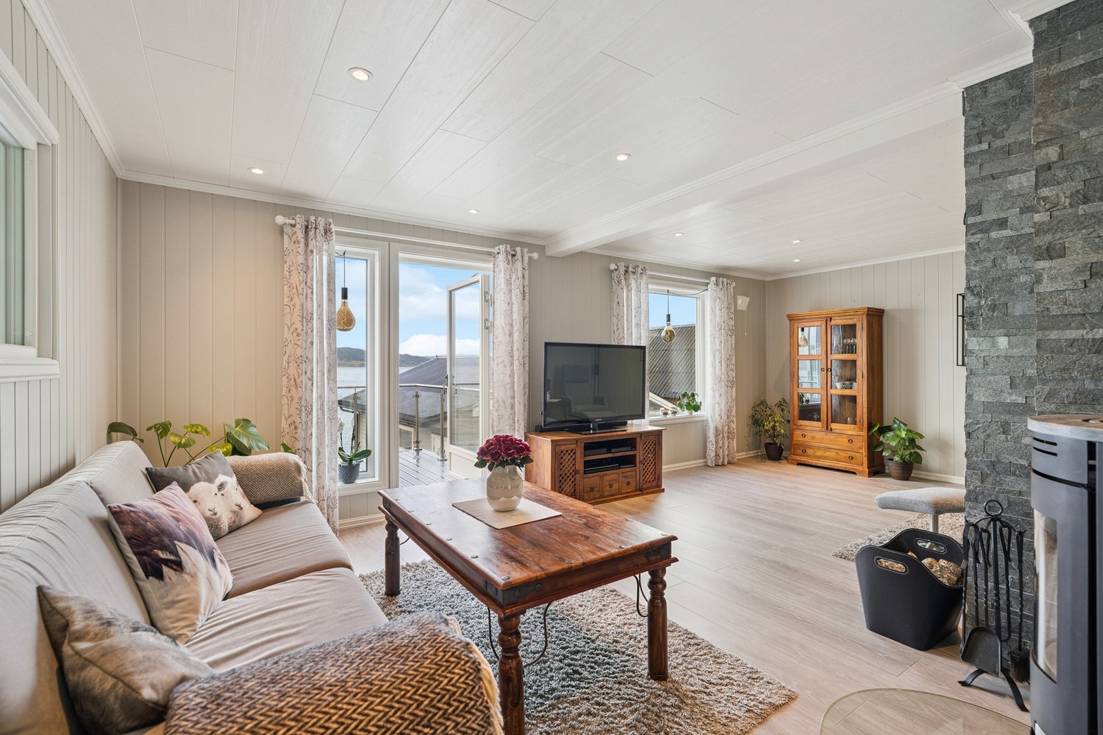 Fin og lys stue med vedovn Galleribilde