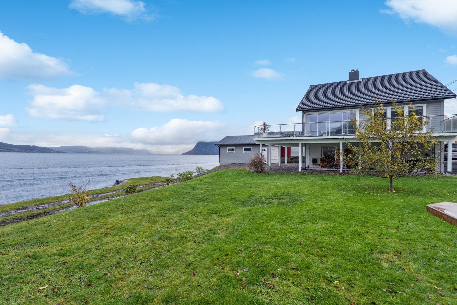 På eiendommen har man et renovert og godt vedlikeholdt hus, garasje og naust Galleribilde