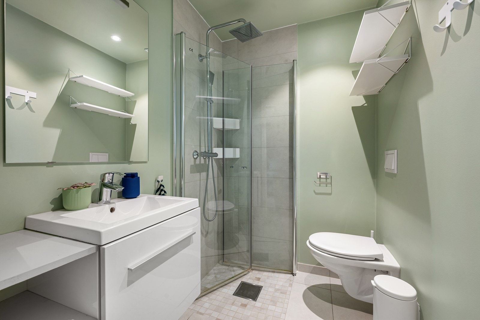 Bad en-suite med dusj med innfellbare dører i herdet glass og veggfestet toalett Galleribilde