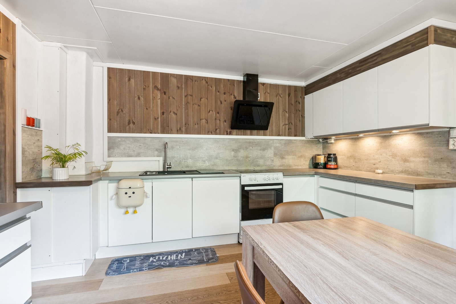 Benkeplaten er i laminat og det er avsatt plass for hvitevarer. I tillegg er det en montert en kjøkkenventilator med avtrekk ut Galleribilde