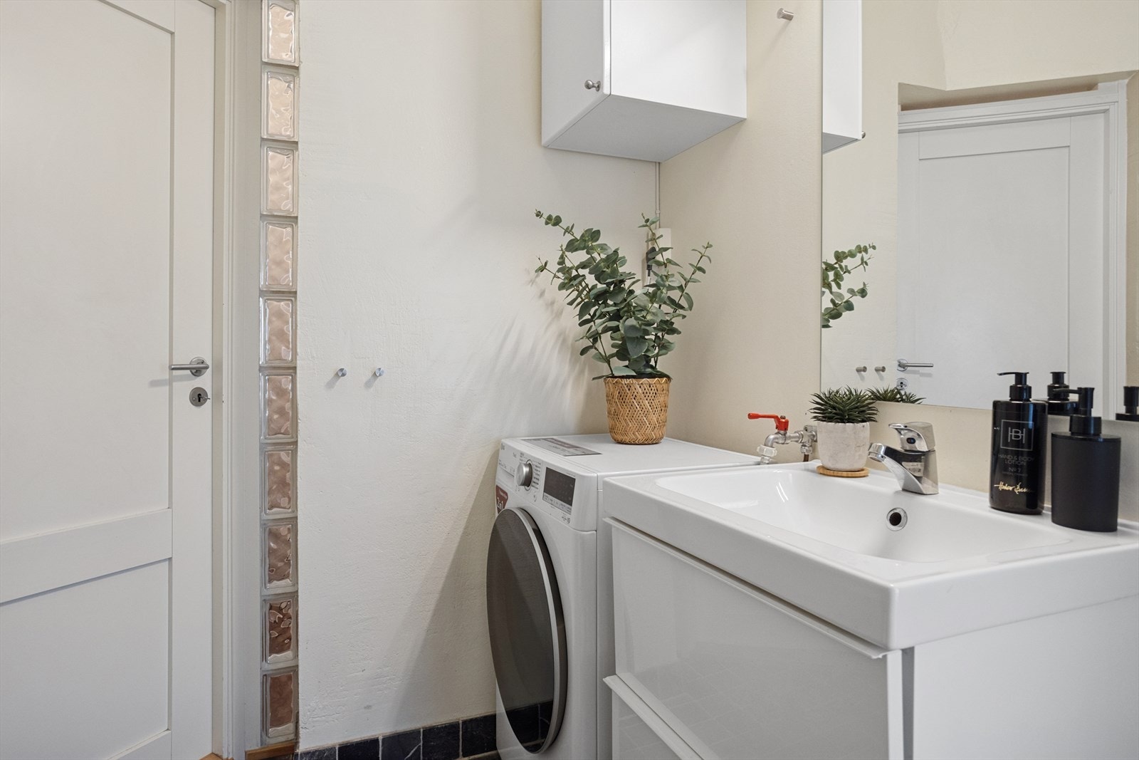 Baderommet har dusjkabinett, gulvmontert toalett, pen skuffinnredning med servant og speil over - det er i tillegg opplegg for vaskemaskin på badet. Galleribilde