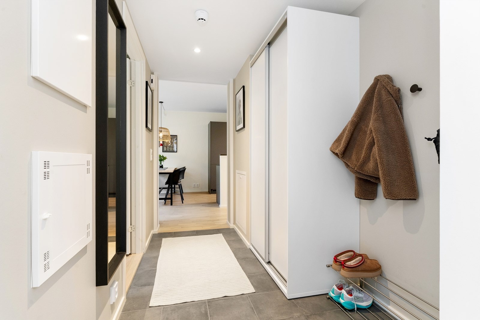 Man ønskes velkommen inn i en romslig entré med garderobeskap med skyvedører samt oppheng for yttertøy. Galleribilde