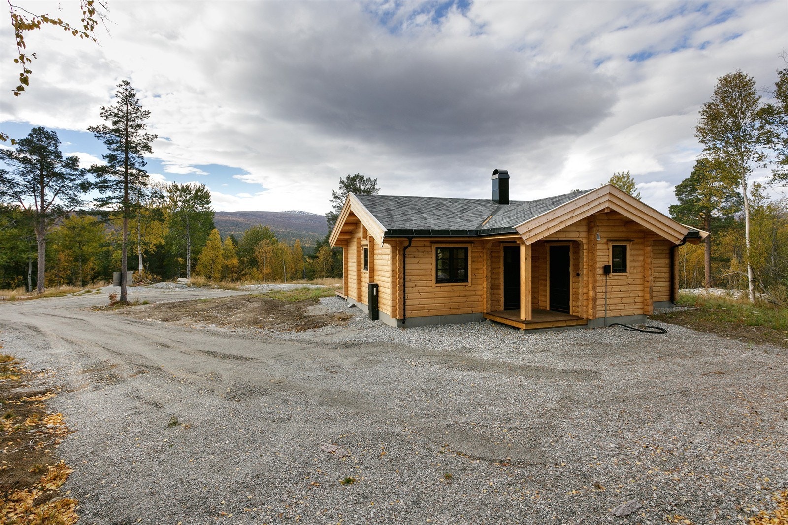 Stor gruslagt gårdsplass med gode parkeringsmuligheter Galleribilde