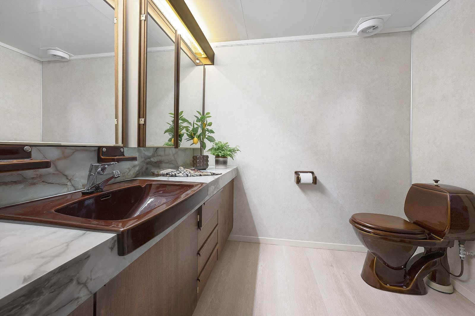 Badet er innredet med servant i underskap, høyskap, speil, toalett og dusjnisje Galleribilde