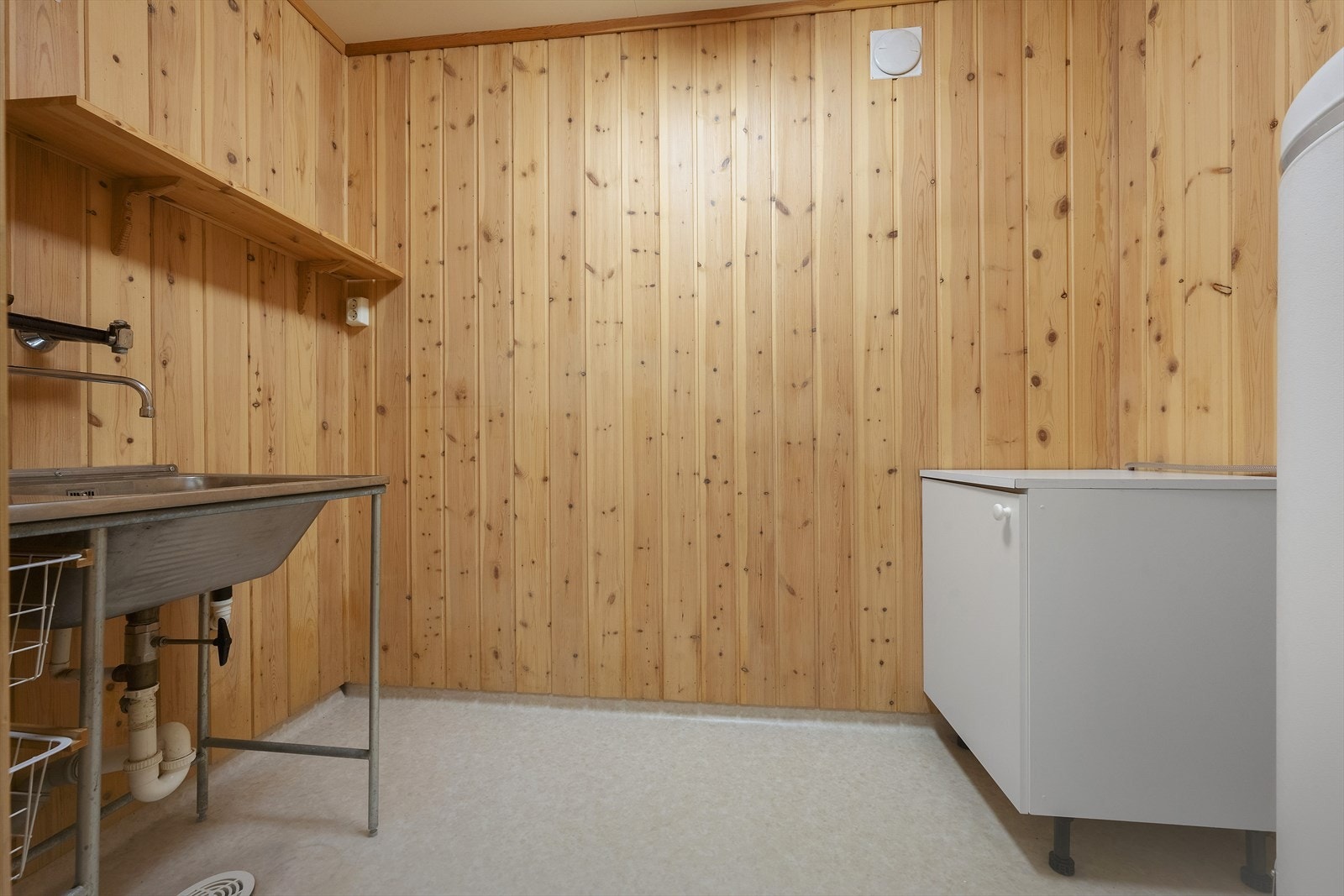 Vaskerommet har belegg på gulv og panel på vegger. Rommet er innredet med seksjon med stål skyllekar, en seksjon med underskap og benkeplate samt opplegg for vaskemaskin. Her er det tilkomst fra bod. Galleribilde