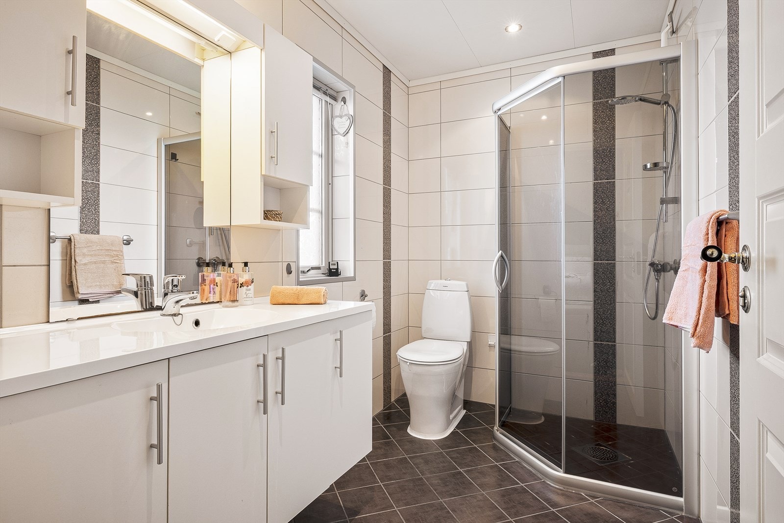 Badet er innredet med servant i møbel, toalett og dusj med skyvedør. Galleribilde