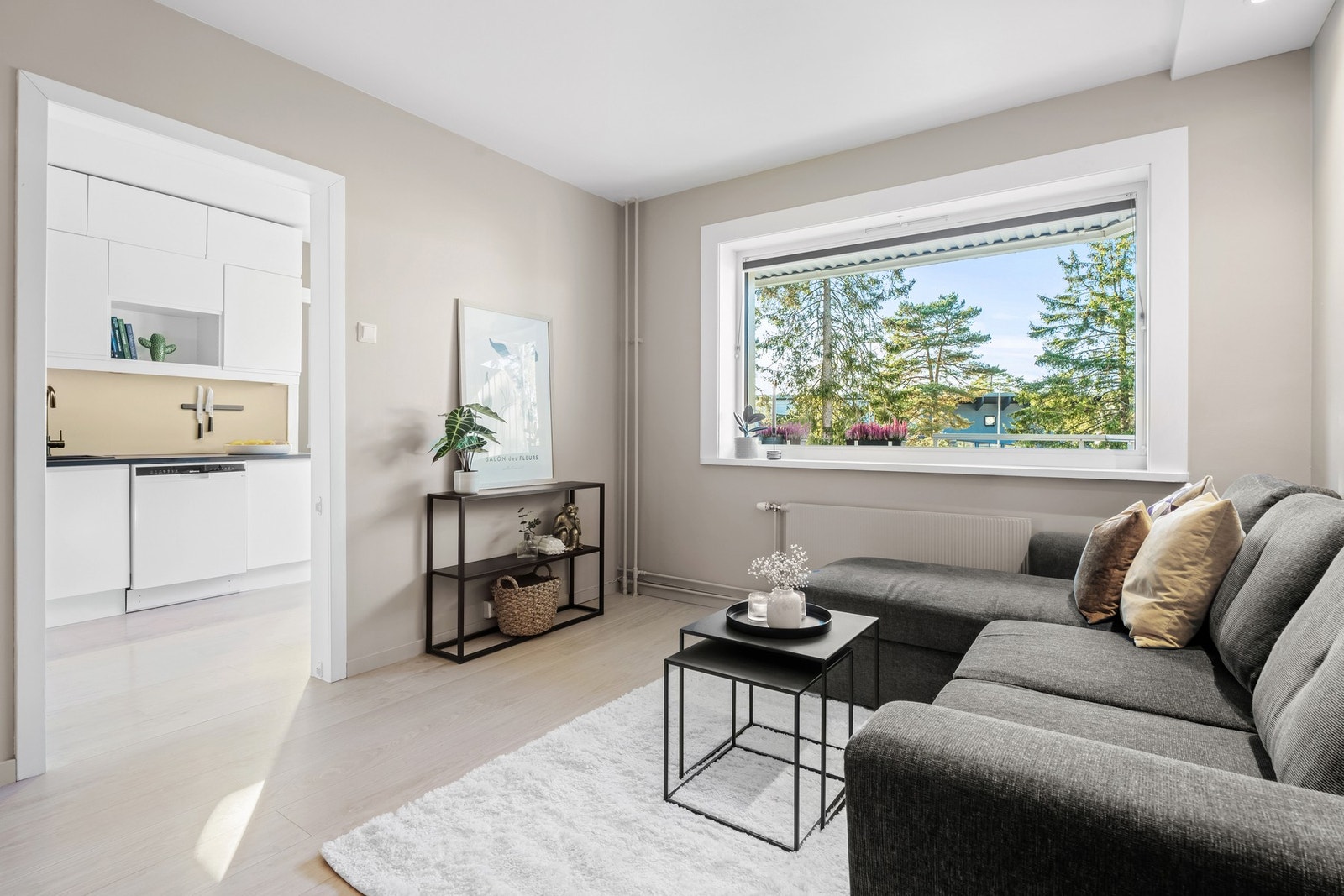 Med sin åpne planløsning mot kjøkkenet, gir rommet gode muligheter for fleksibel møblering, enten du ønsker en tradisjonell sofagruppe eller en mer moderne løsning Galleribilde