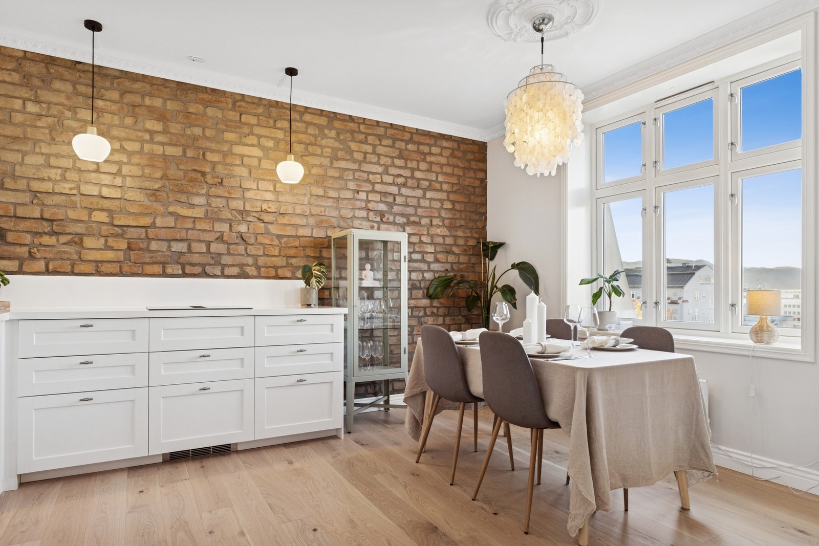 Spisestuen har en naturlig plassering ved vinduene og fungerer som et trivelig samlingspunkt for både hverdag og gjester. Galleribilde