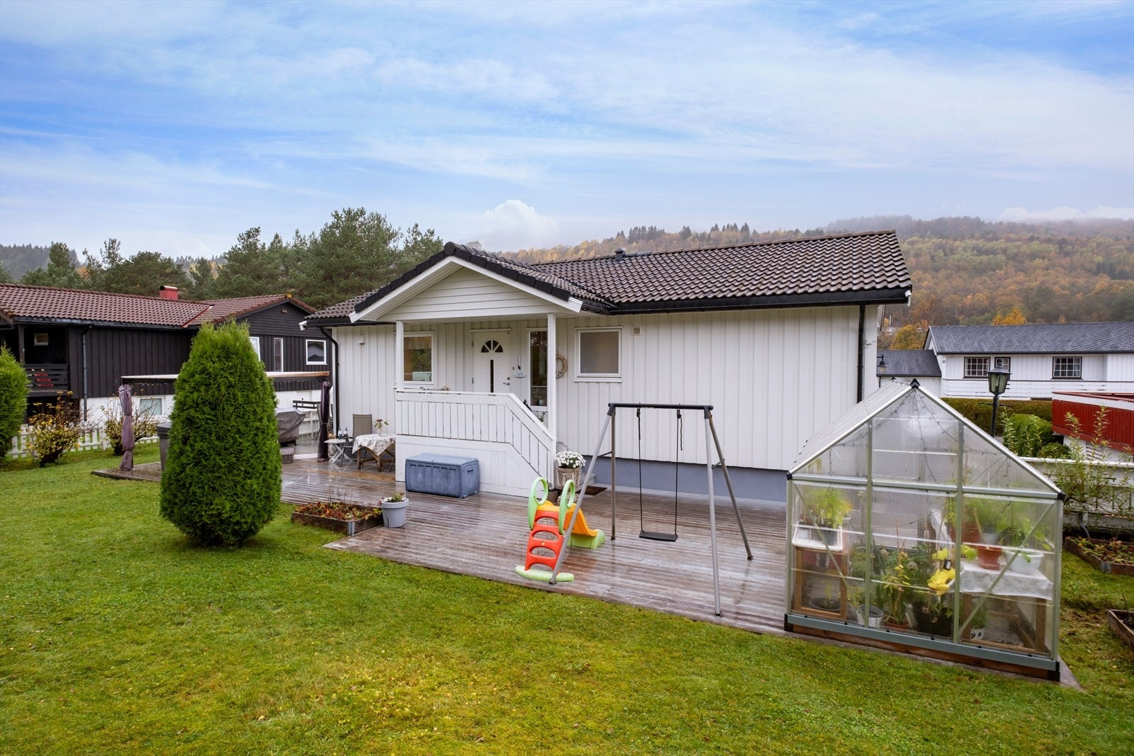 Boligen går over 2 etasjer, har garasje og fin gressplen rundt huset Galleribilde