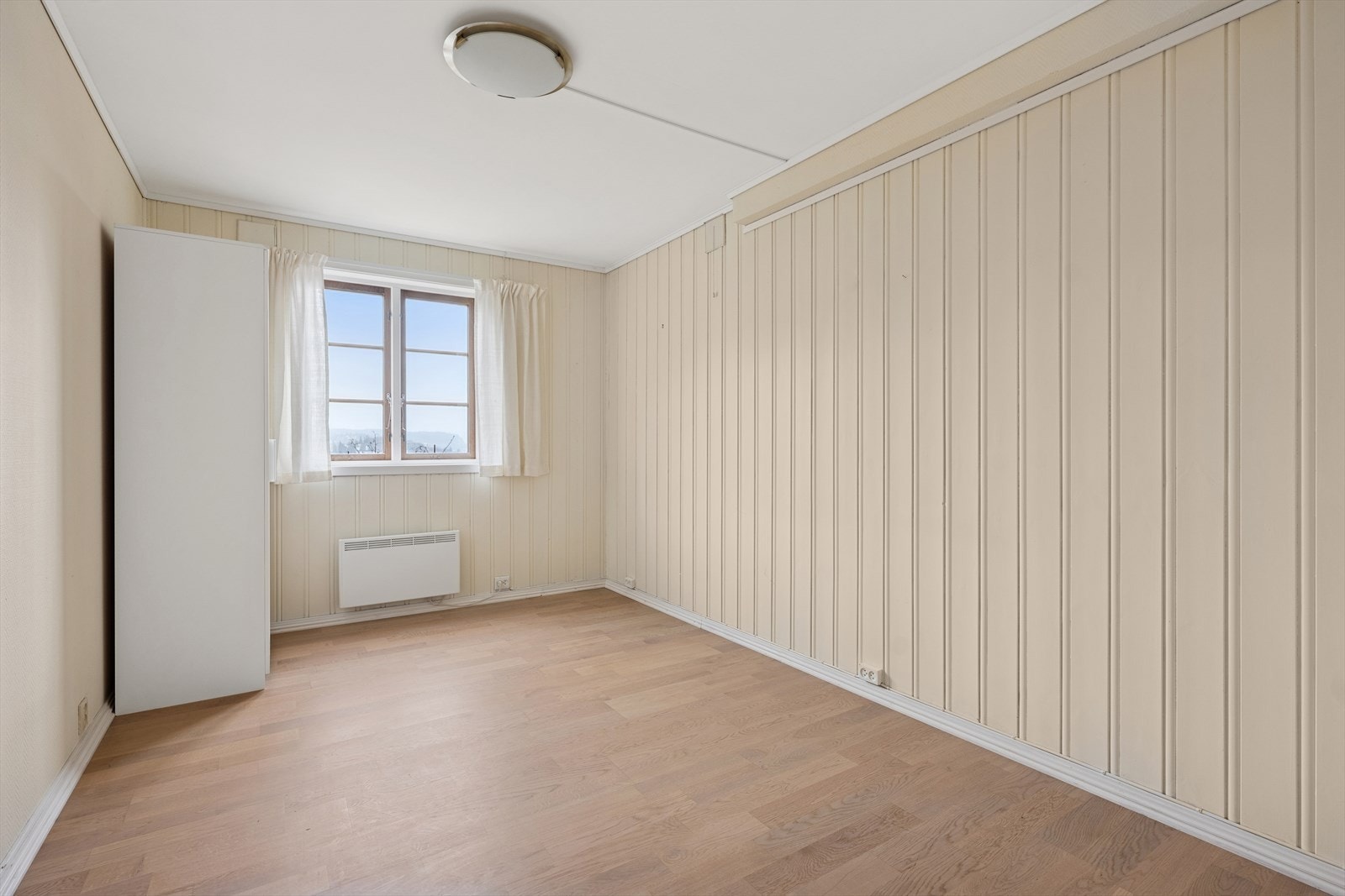 Soverom med lyse overflater, plass til seng og garderobeskap. Galleribilde