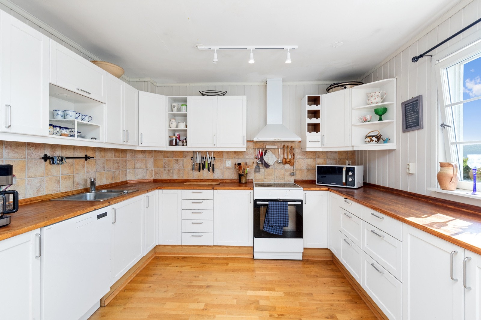 Delvis åpent kjøkken med god skap- og benkeplass. Galleribilde