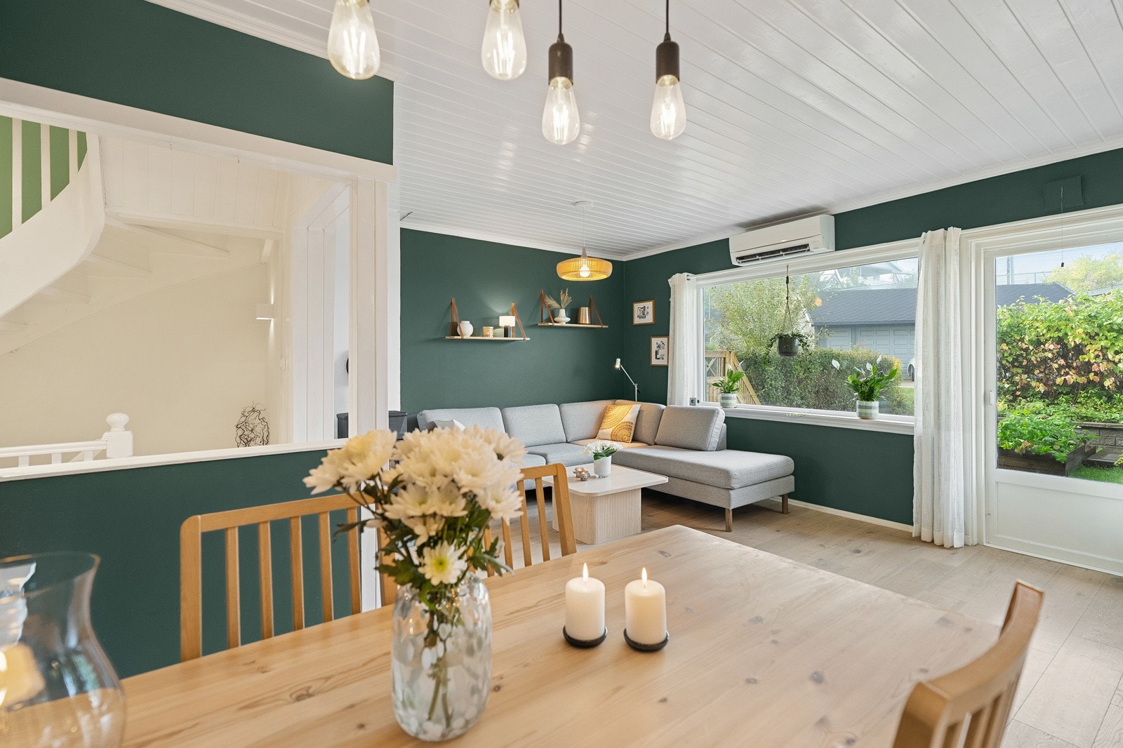 Stuens utforming gir plass til å innrede med både sofagruppe og spisebord. Vedovn og varmepumpe. Galleribilde