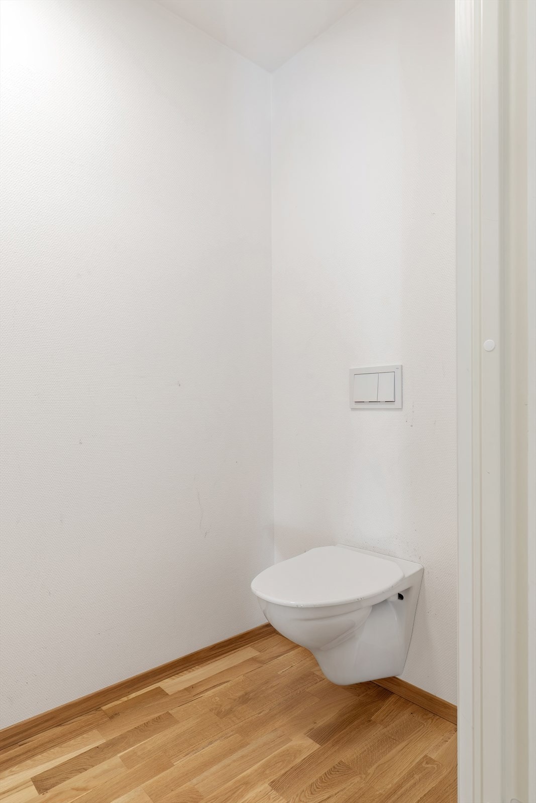 Toalettrommet har vegghengt toalett og lysmalte vegger. Galleribilde