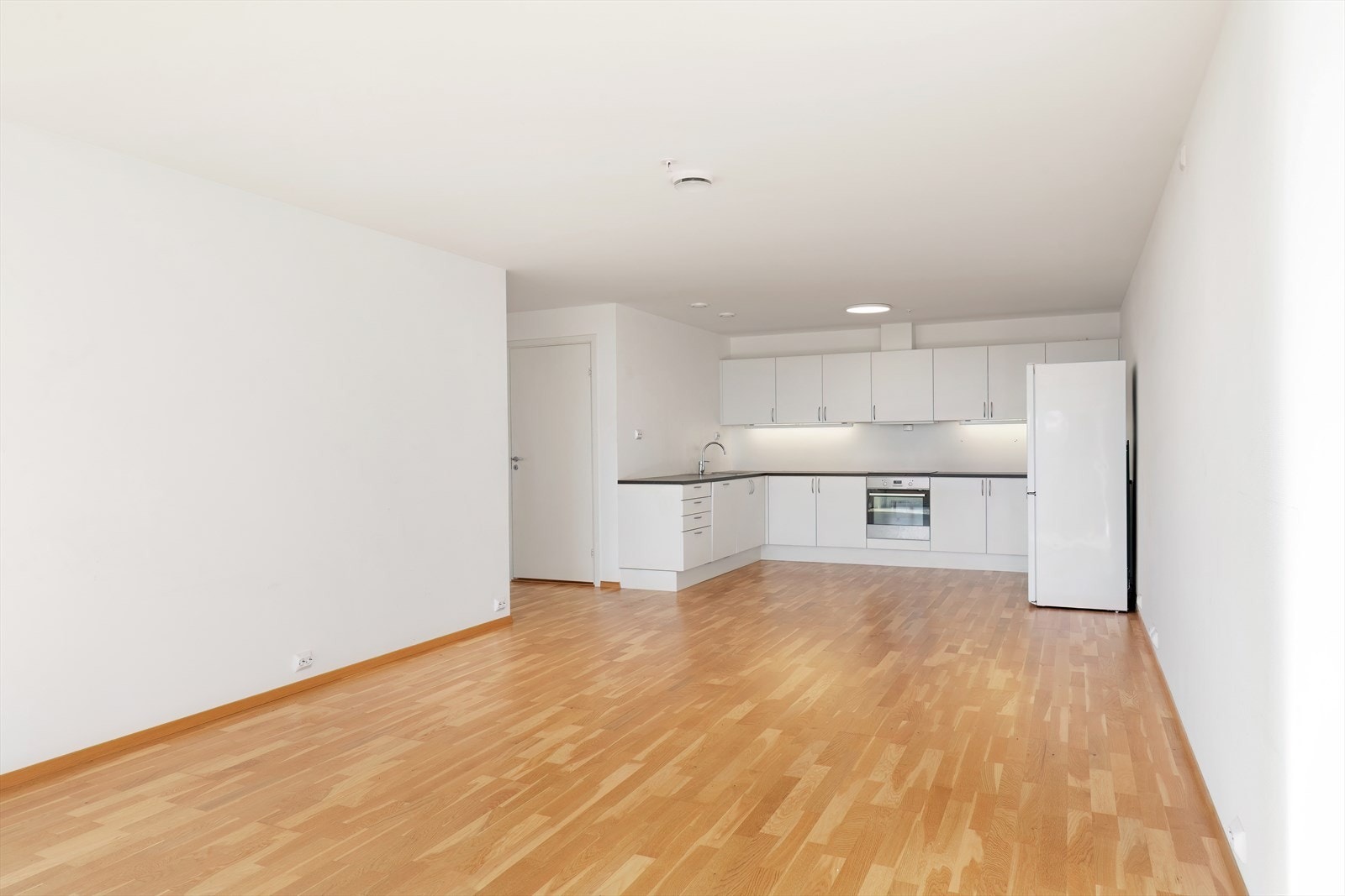 Åpen kjøkkenløsning med hvite fronter gir en lys og romslig atmosfære. Galleribilde