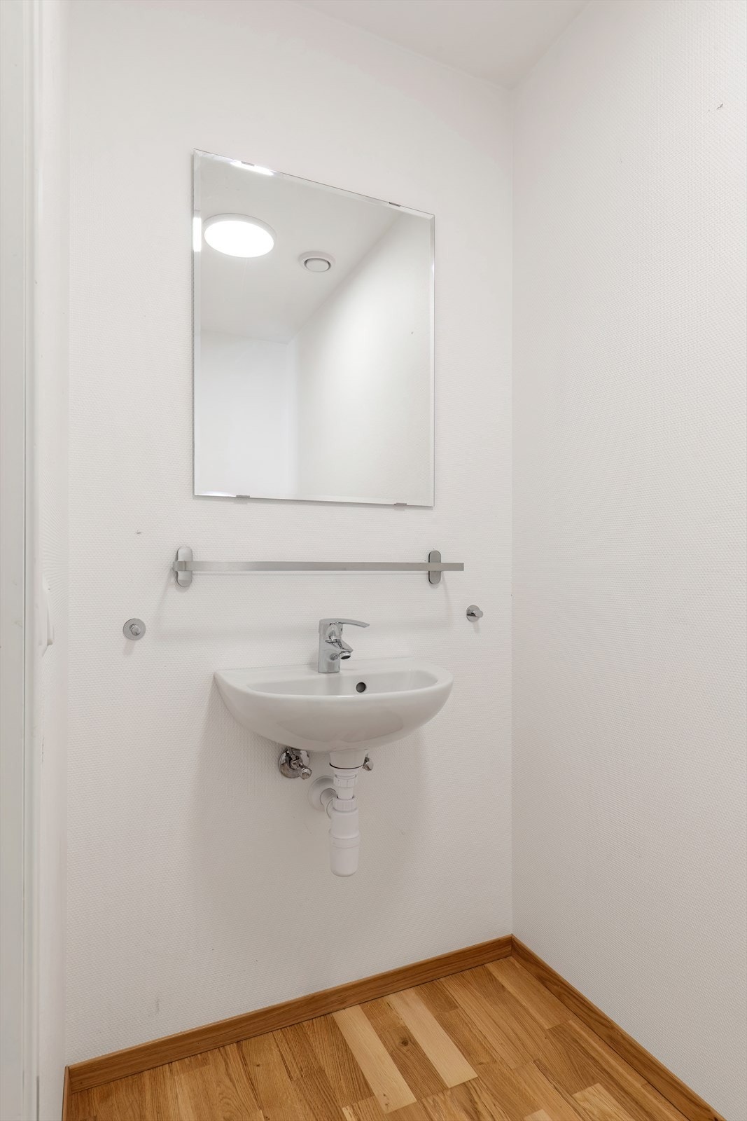 Vegghengt servant med speil gir et kompakt og funksjonelt toalettrom. Galleribilde