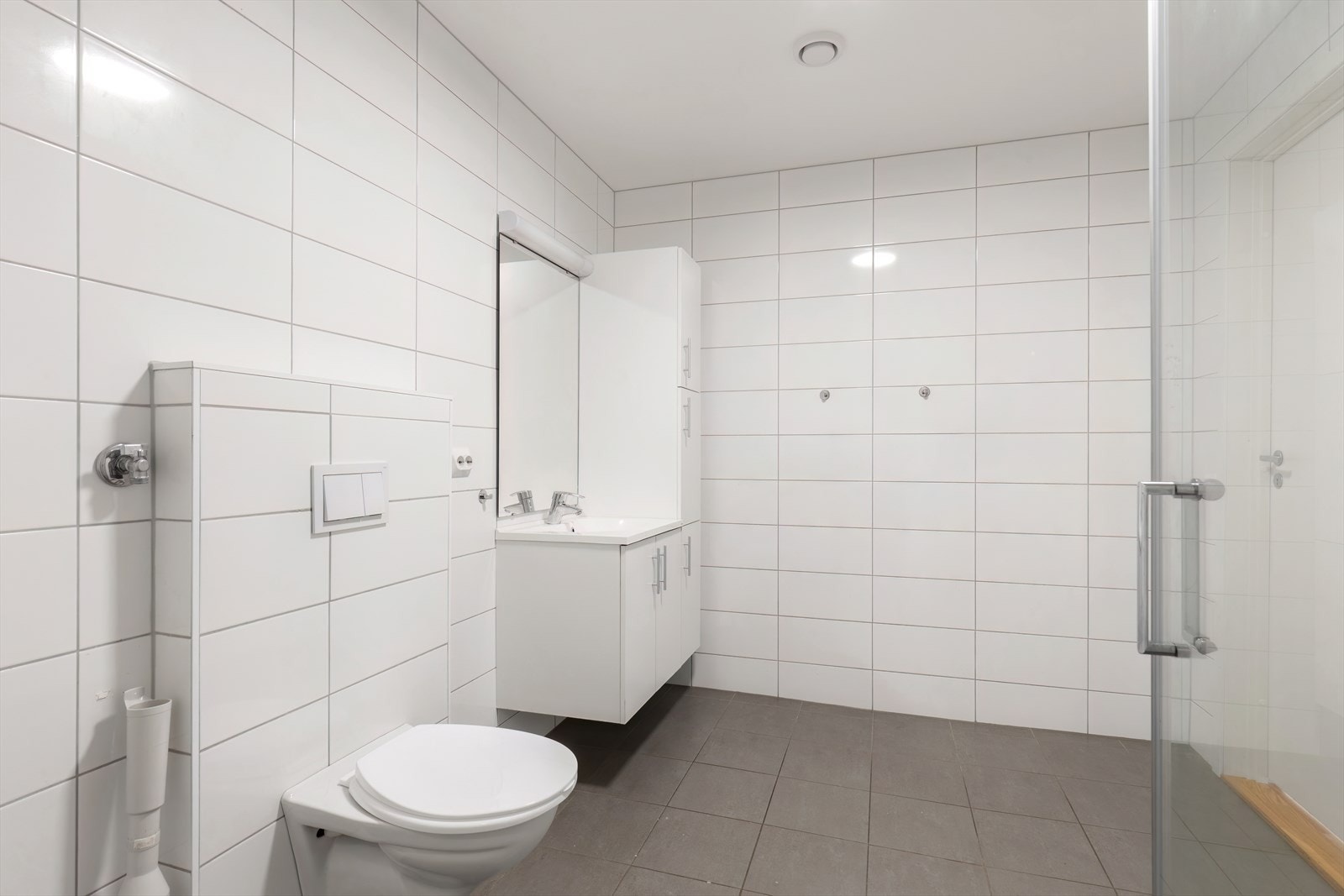 Flislagte vegger og gulv gir et lettstelt bad med praktisk dusjhjørne (kilde: tilstandsrapport). Galleribilde