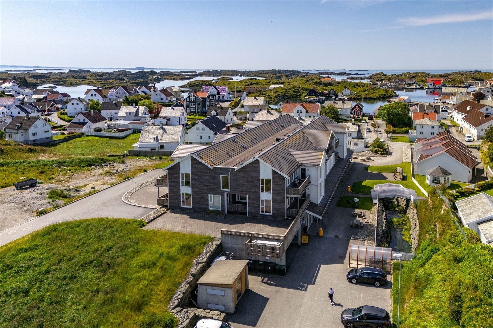 Utsikt over et kystnært boligområde med flere eneboliger og leilighetsbygg gir et godt inntrykk av nærmiljøet. Galleribilde