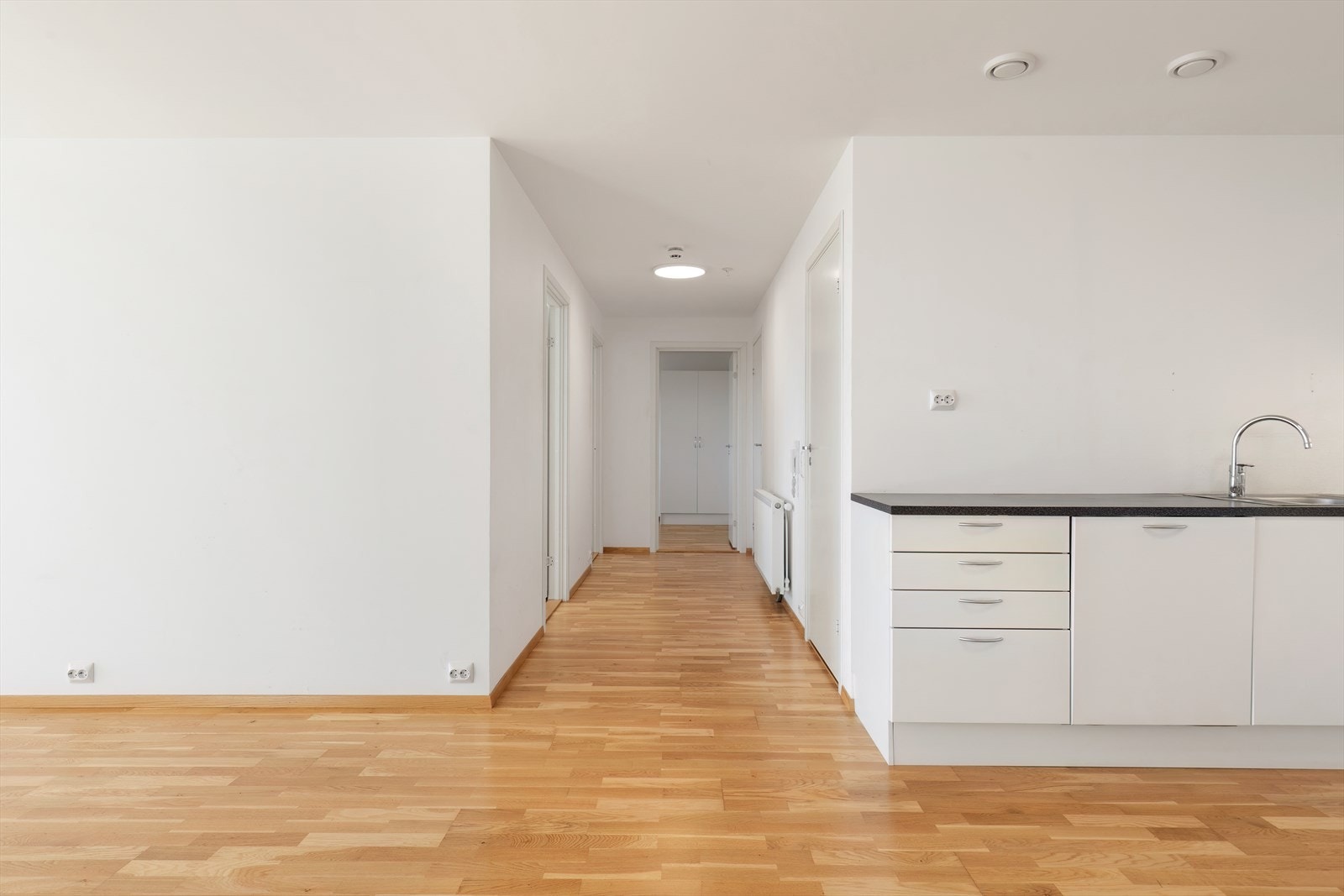 Lyst kjøkken med hvite fronter og mørk benkeplate gir en kontrastfylt arbeidsflate (kilde: tilstandsrapport). Galleribilde