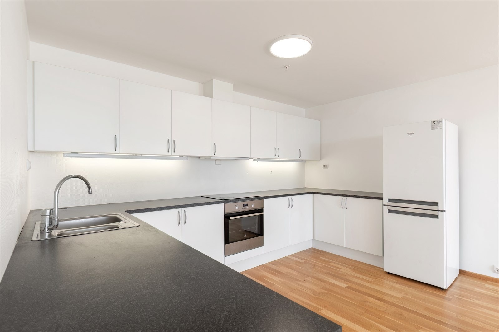 Hvite fronter og integrert stekeovn gir et ryddig kjøkkenmiljø (kilde: tilstandsrapport). Galleribilde